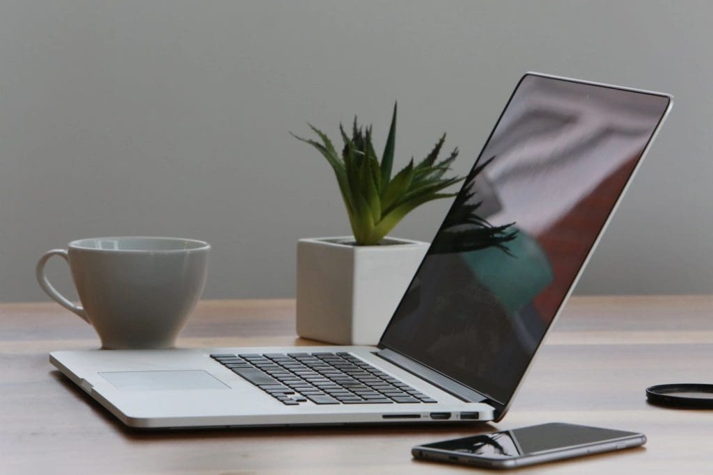 Laptop, Coffee and Phone sitting on a desk