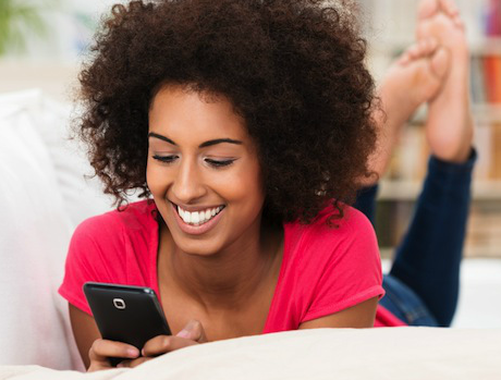 Girl on couch texting for a quote for Internet and Satellite TV service.