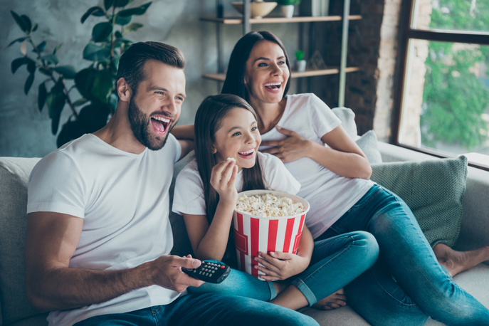 Family eating popcorn watching TV