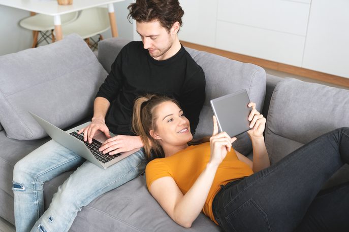 Man and Woman on the couch surfing the internet